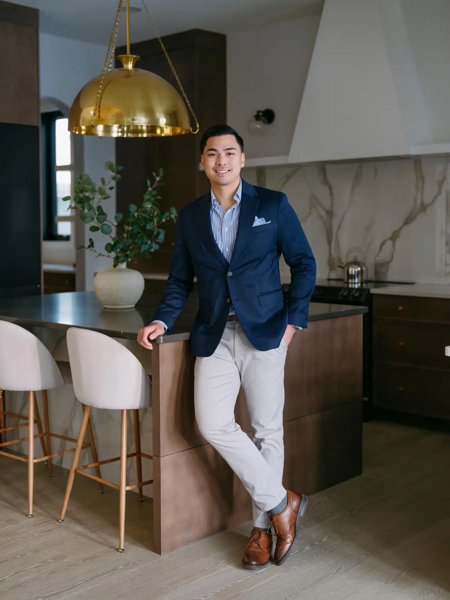 Mikee Canasa, who provides Edmonton Real Estate Services, standing in a kitchen of a beautiful home in Edmonton.